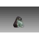 A Green and Brown Jade Seated Lion, Ming dynasty,