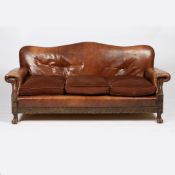 A 20TH CENTURY LEATHER AND OAK THREE SEATER SETTEE.