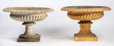 A NEAR PAIR OF CAST IRON GARDEN URNS.