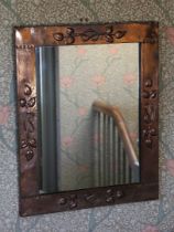 AN ARTS AND CRAFTS COPPER WALL MIRROR.