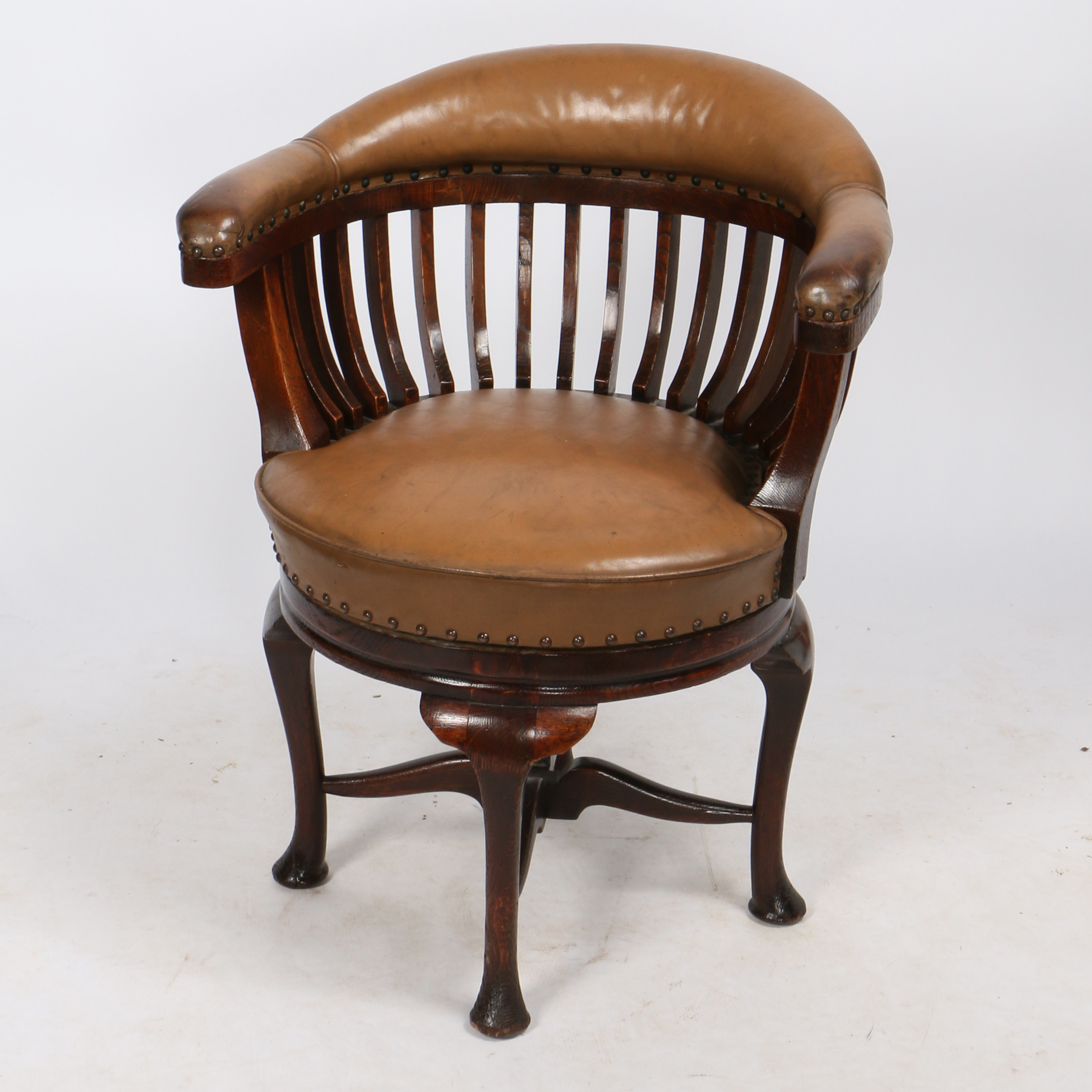 AN EARLY 20TH CENTURY OAK AND LEATHER CAPTAIN'S SWIVEL DESK CHAIR.
