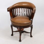 AN EARLY 20TH CENTURY OAK AND LEATHER CAPTAIN'S SWIVEL DESK CHAIR.