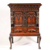 A 19TH CENTURY CARVED OAK CUPBOARD ON STAND.