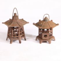 A NEAR PAIR OF EARLY TO MID 20TH CENTURY CAST IRON PAGODA CANDLE HOLDER LANTERNS.