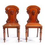 A PAIR OF VICTORIAN ARMORIAL BACK MAHOGANY HALL CHAIRS ATTRIBUTED TO W. BLACKIE.