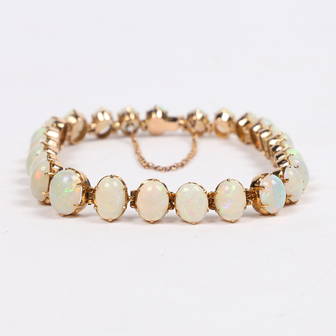 A YELLOW METAL AND OPAL BRACELET.