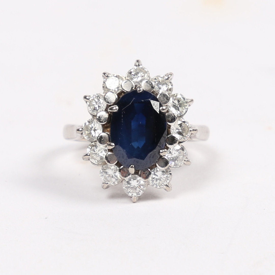 AN 18 CARAT WHITE GOLD, SAPPHIRE AND DIAMOND CLUSTER RING.