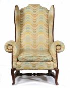 A GEORGE I/II OAK AND UPHOLSTERED WING ARMCHAIR, CIRCA 1730.