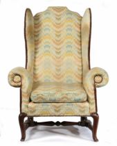 A GEORGE I/II OAK AND UPHOLSTERED WING ARMCHAIR, CIRCA 1730.