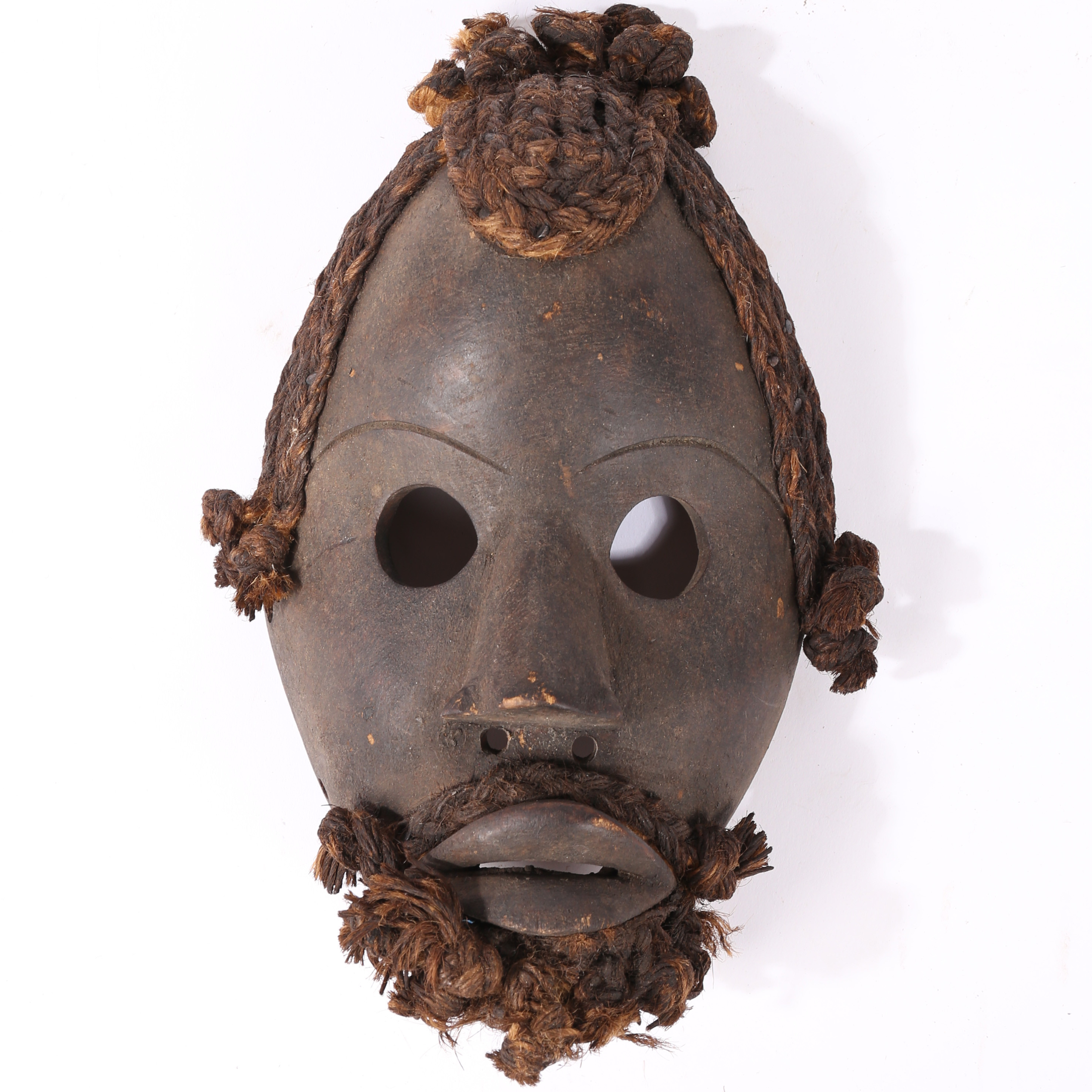AN AFRICAN TRIBAL CARVED DAN MASK IVORY COAST/CÔTE D'IVOIRE.