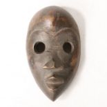 AN AFRICAN TRIBAL CARVED DAN MASK IVORY COAST/CÔTE D'IVOIRE.