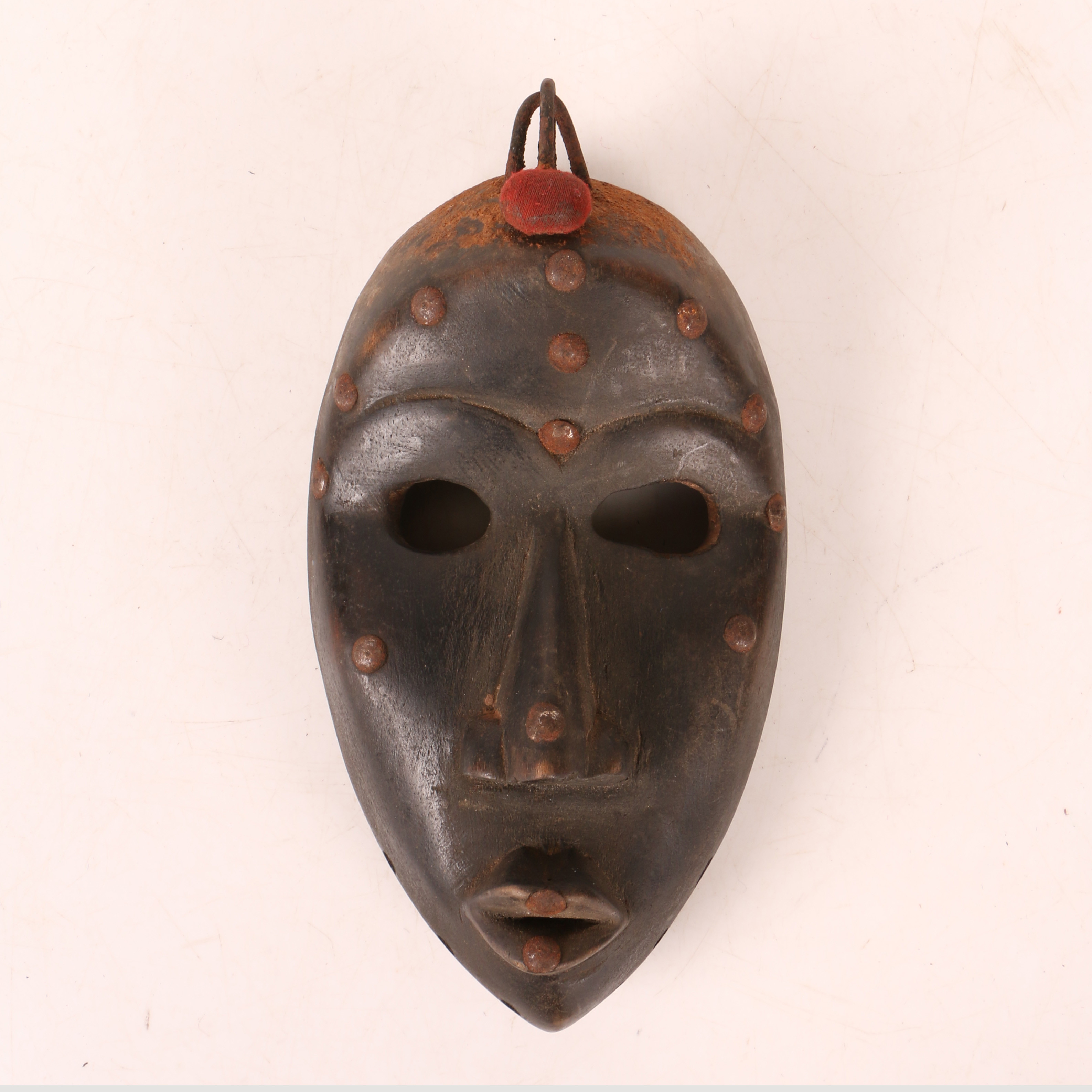 AN AFRICAN TRIBAL CARVED DAN MASK IVORY COAST/CÔTE D'IVOIRE.