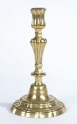 A MID-18TH CENTURY BRASS CANDLESTICK, ROCOCO MANNER, CIRCA 1755.