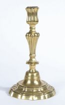 A MID-18TH CENTURY BRASS CANDLESTICK, ROCOCO MANNER, CIRCA 1755.