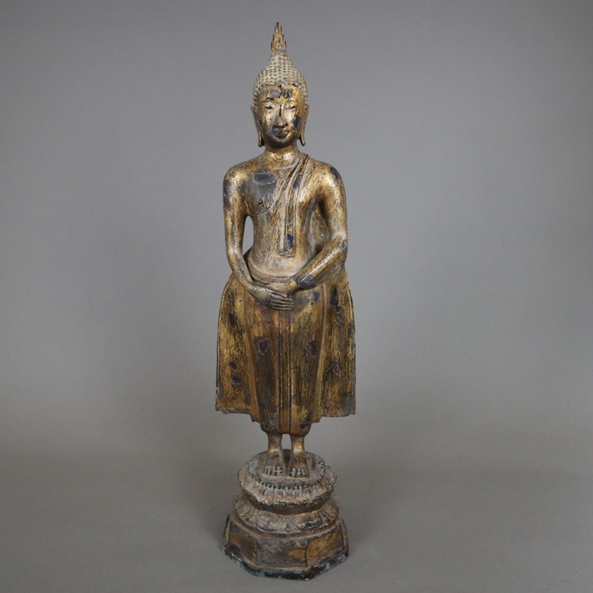 Stehende Buddhafigur - Thailand, Bronze mit Resten der Goldlackvergoldung, auf Lotossockel mit poly