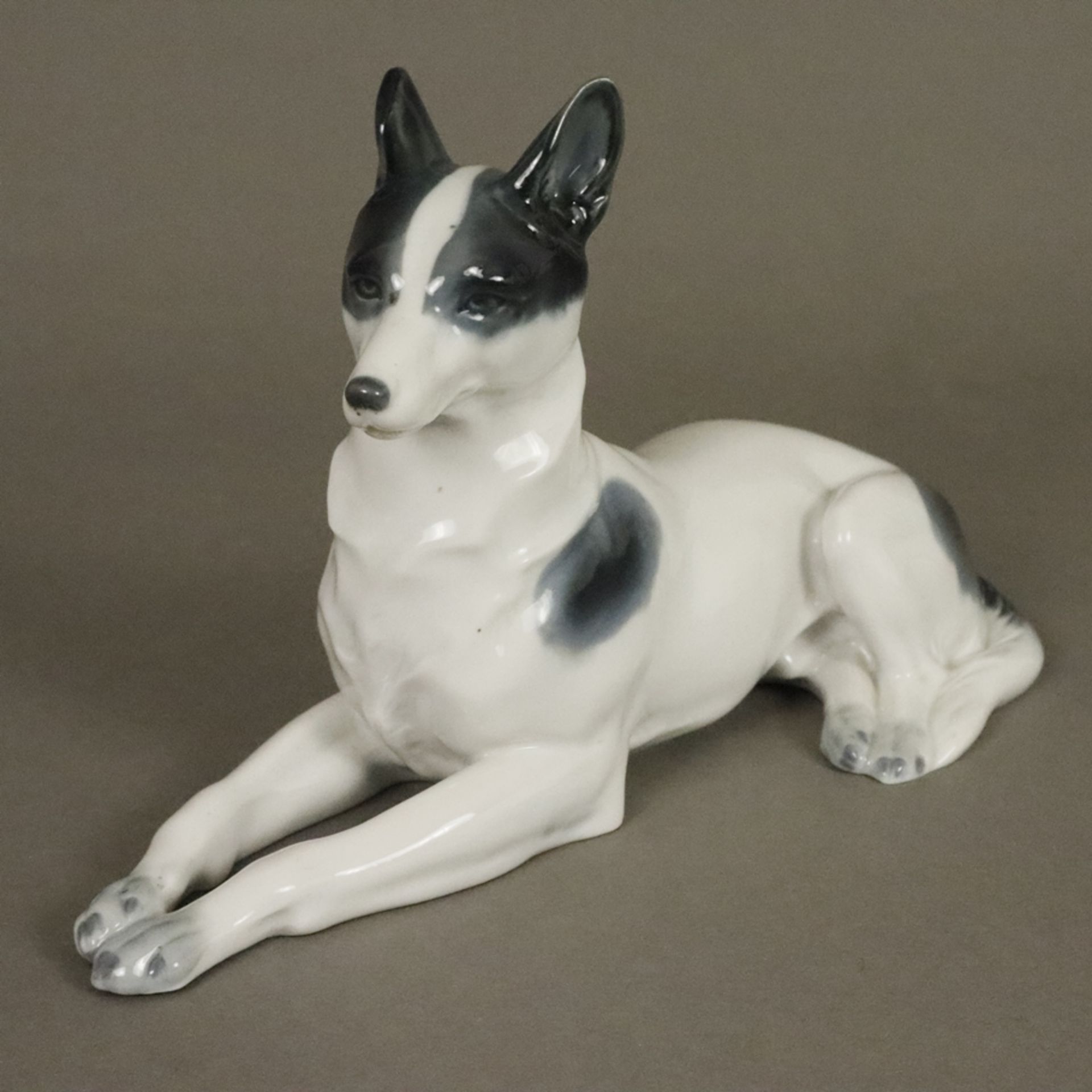 Liegende Hundefigur - Metzler & Orloff, Porzellan glasiert in Grau-Schwarztönen staffiert, Bodenmar
