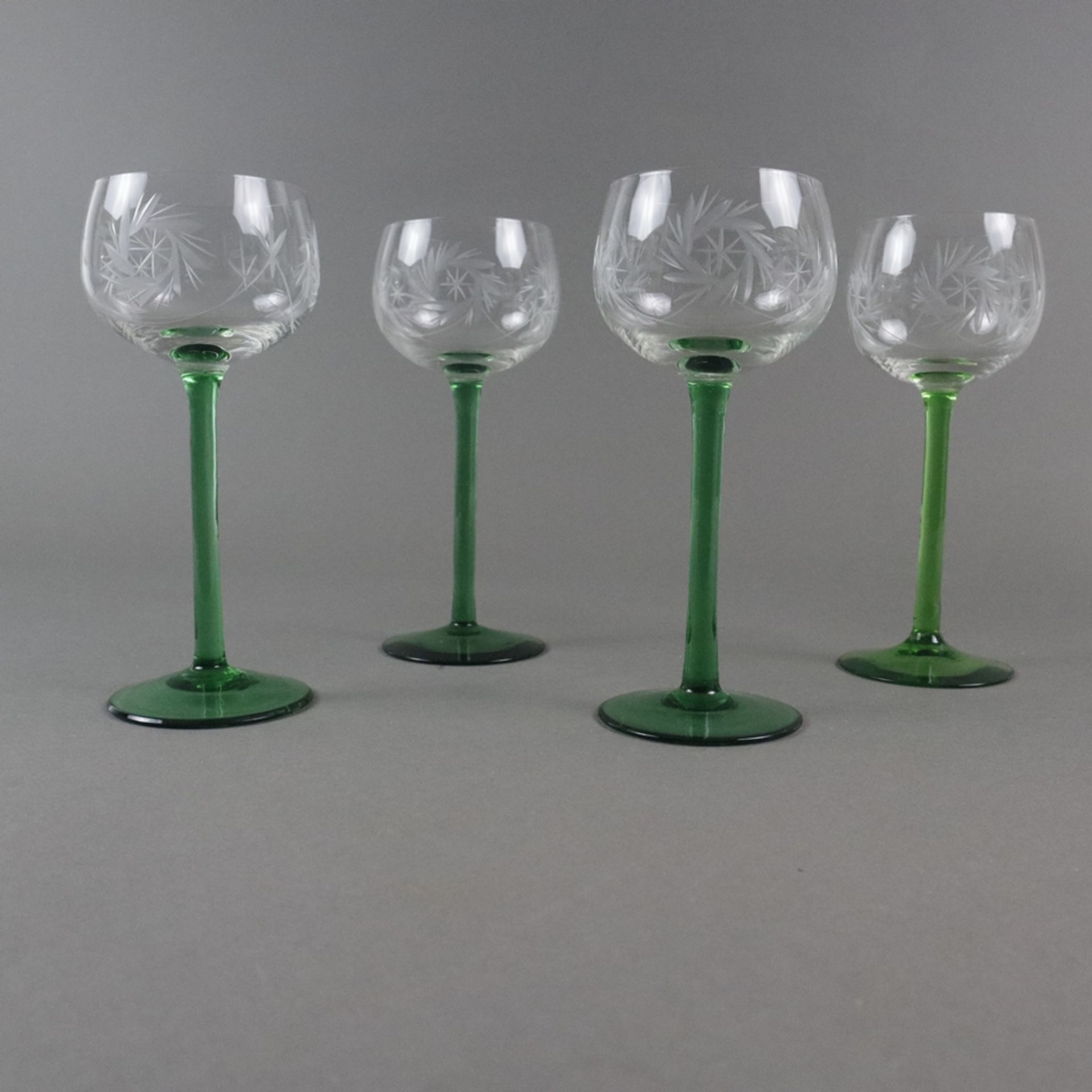 Vier Fußgläser - Kelch farbloses Glas mit Gravurdekor, Schaft und Rundfuß grünes Glas (1x im Farbto