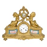 A LOUIS XVI STYLE PORCELAIN INSET GILT BRONZE FIGURAL MANTEL CLOCKLate 19th/early 20th century