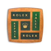 A large wooden shop sign with glass panels and gilt lettering bearing the name Rolex Circa 1950