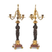 A pair of third quarter 19th century French gilt and patinated bronze three light figural candel...