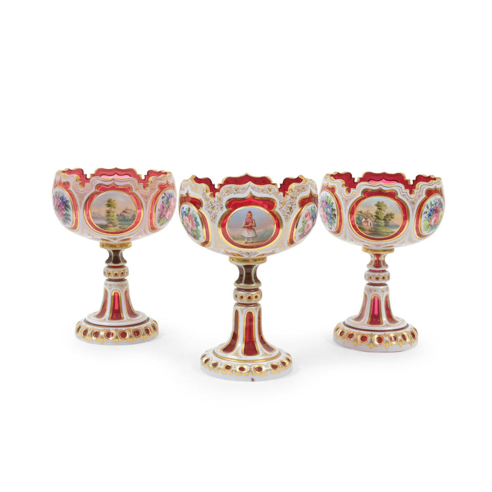 A late 19th century Bohemian overlaid ruby glass pedestal bowl and a similar pair of pedestal bowls