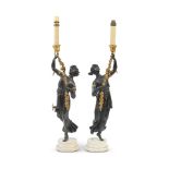 A pair of early 19th century and later patinated and gilt bronze figural candle holders, later a...