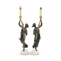 A pair of early 19th century and later patinated and gilt bronze figural candle holders, later a...