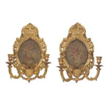 A pair of 19th century carved and gilt gesso twin light girandoles with later inset needlework p...