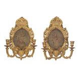 A pair of 19th century carved and gilt gesso twin light girandoles with later inset needlework p...