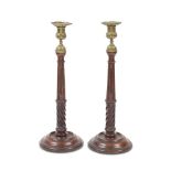 A pair of 19th century turned and carved mahogany and brass candlesticks In the George III style...