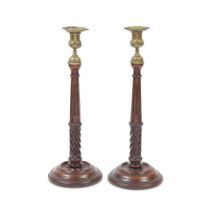 A pair of 19th century turned and carved mahogany and brass candlesticks In the George III style...