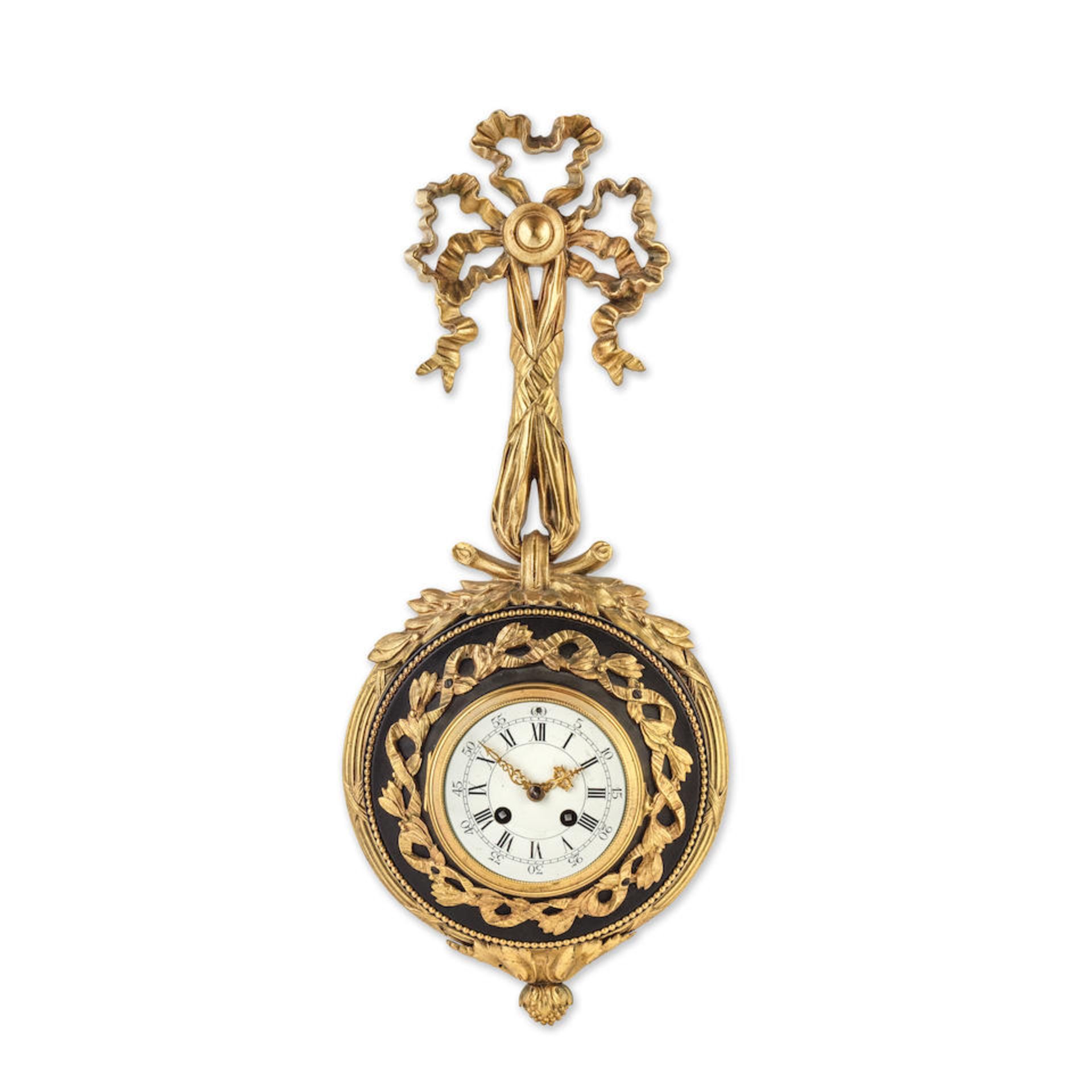 An early 20th century French gilt and patinated bronze cartel clock in the Louis XVI taste