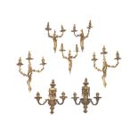 A pair of twin light gilt brass wall appliques, together with a pair of three light gilt brass w...