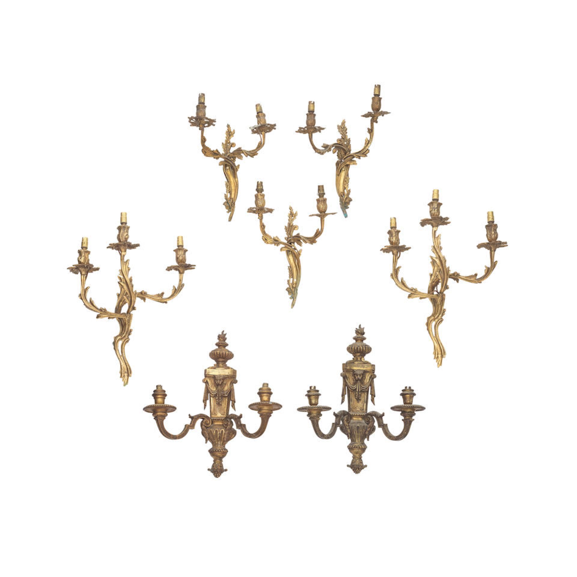 A pair of twin light gilt brass wall appliques, together with a pair of three light gilt brass w...