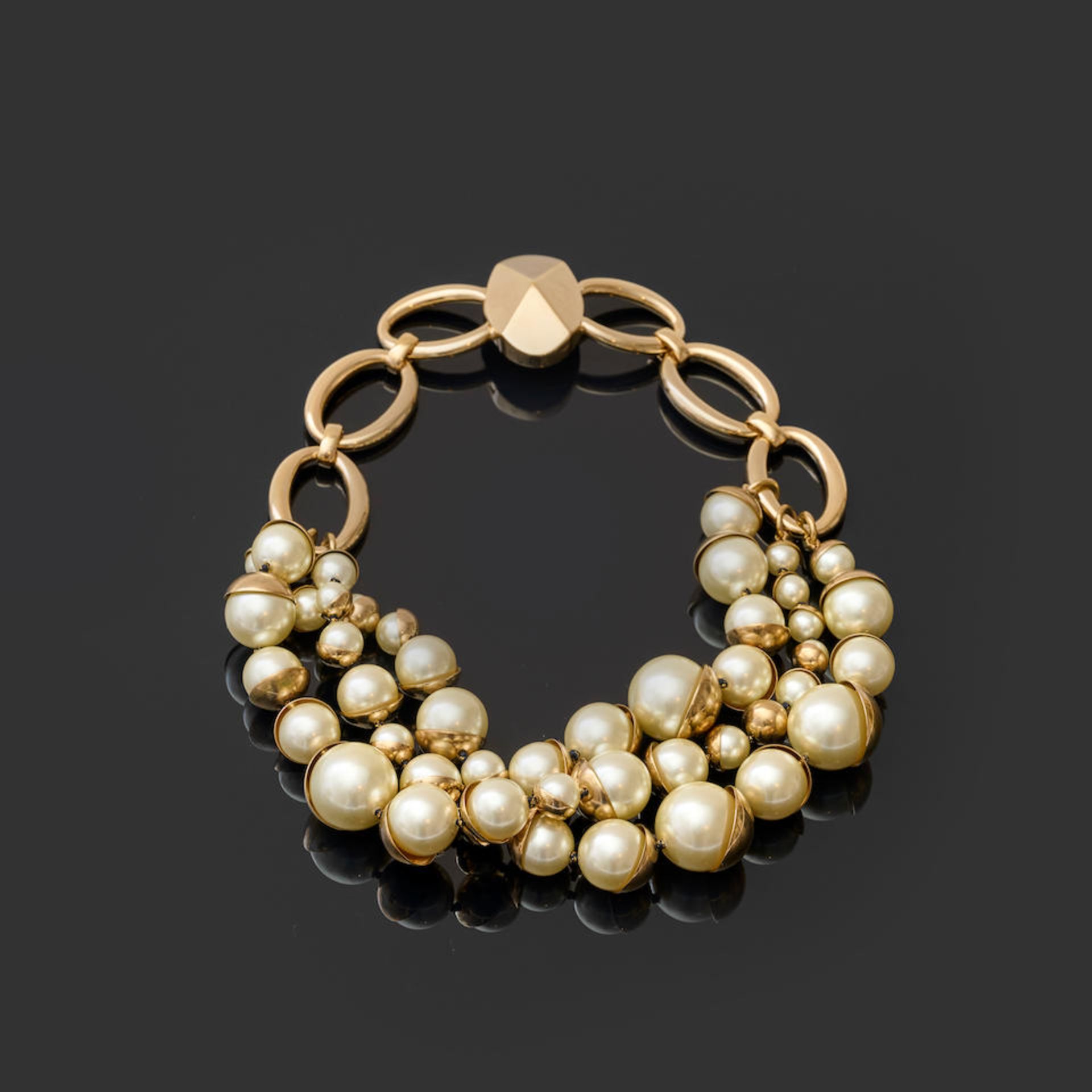 Christian DIOR. Collier chaine en métal doré retenant trois rangs de perles d'imitation.