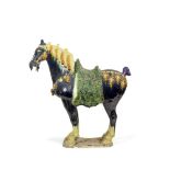 A blue and sancai glazed earthenware model of a horse in the Tang style