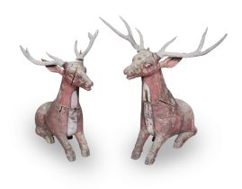 A pair of late 20th century far Eastern carved and red painted hardwood models of recumbent deer...