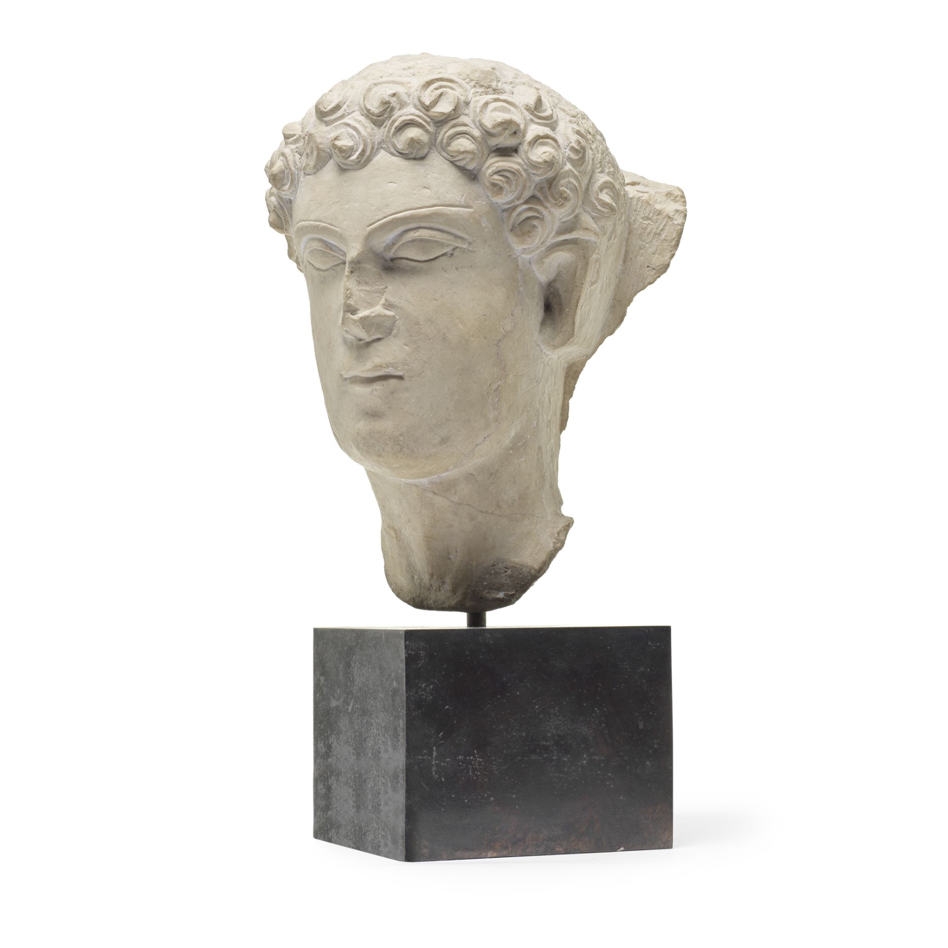 A carved marble bust fragment of a stylised male head in the antique style