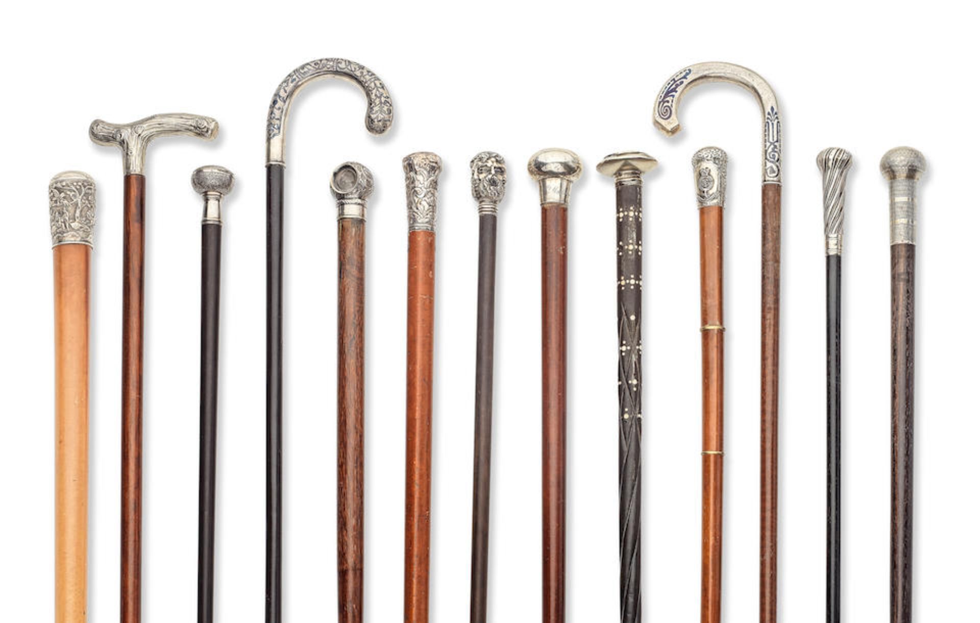 A collection of thirteen silver, white metal and other metal mounted walking sticks and canes in...