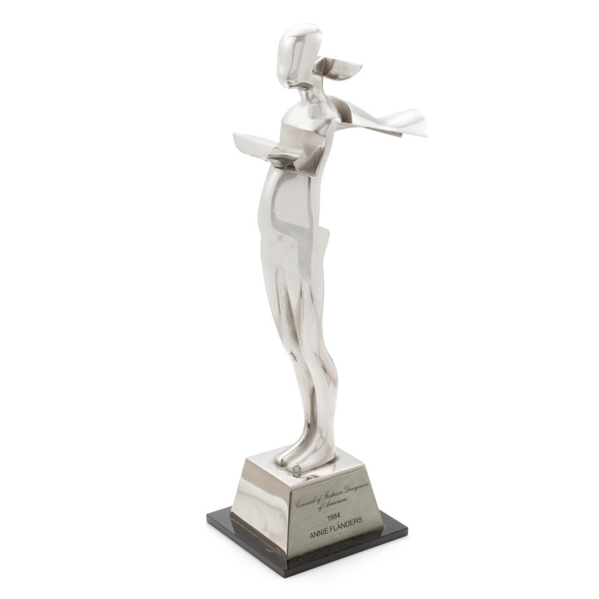 AN ANNIE FLANDERS 1984 CFDA AWARD STATUETTE. TROVA, ERNEST, after. Stainless steel statuette on ...