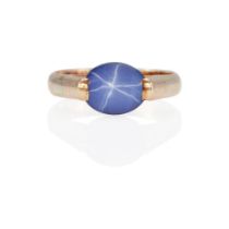 AN 18K GOLD AND SYNTHETIC STAR SAPPHIRE RING