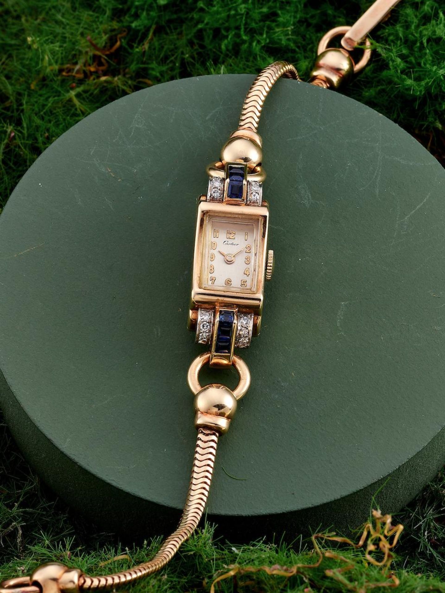 CARTIER | A RARE AND ELEGANT 14K YELLOW GOLD, BLUE SAPPHIRE AND DIAMOND-SET BRACELET WATCH WITH ...