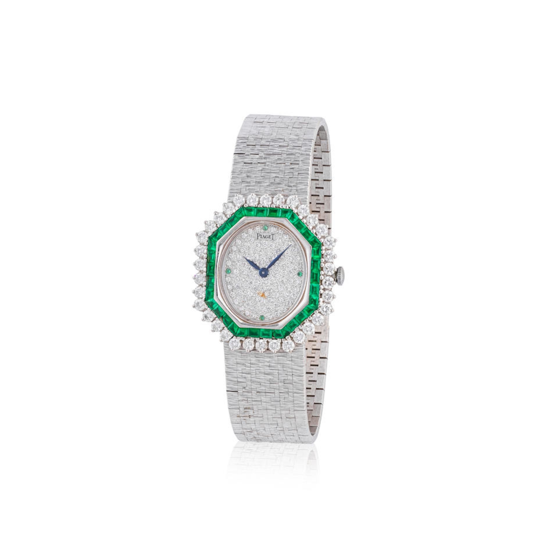 Piaget. A fine lady's 18K white gold manual wind bracelet watch with diamond and emerald set dia...