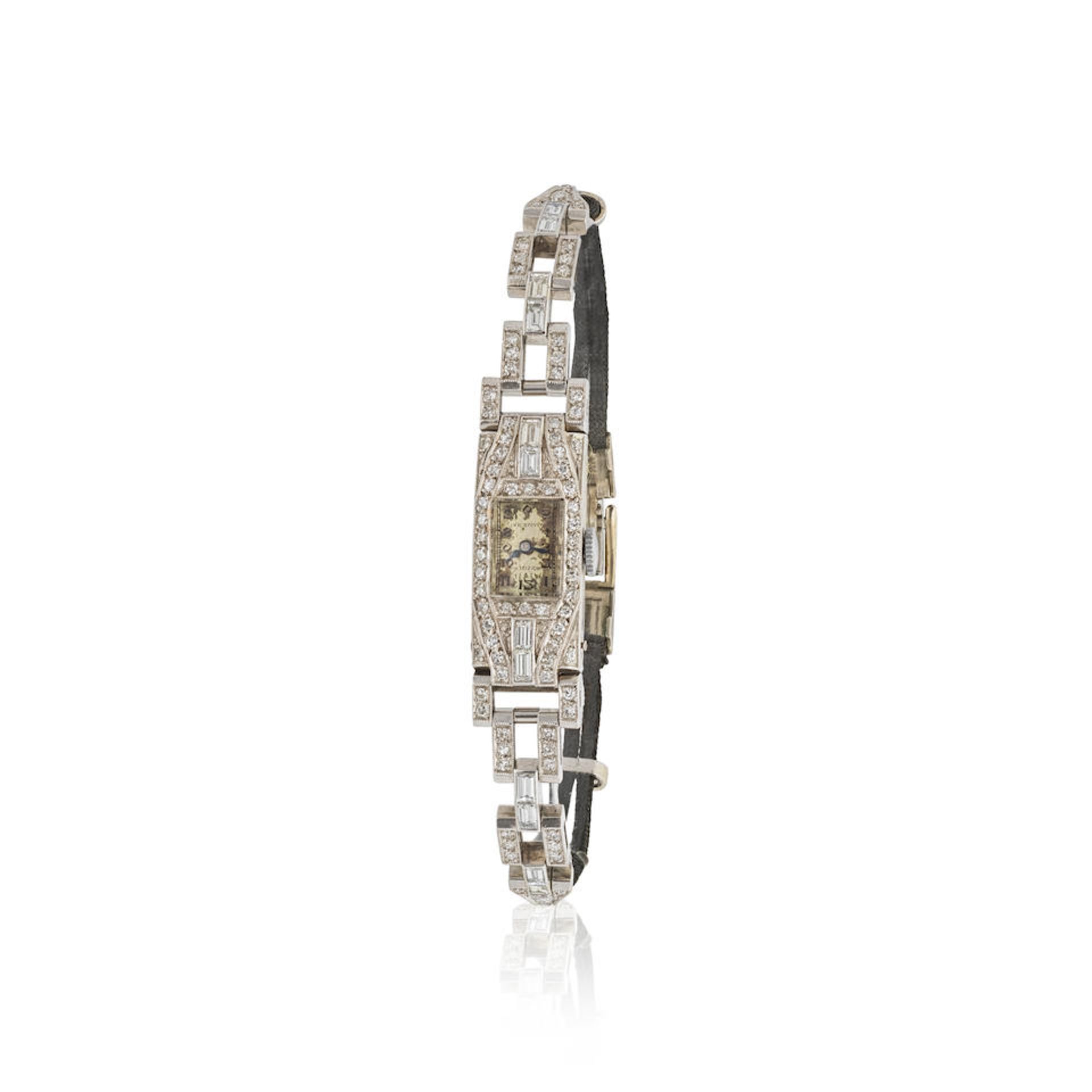 Nivia. A lady's platinum manual wind wristwatch with diamond set bezel Nivia. Montre de dame en ...