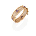 A 19K GOLD AND SYNTHETIC COLOR-CHANGE SAPPHIRE BANGLE