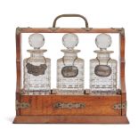 EDWARDIAN BRASS BOUND OAK TANTALUS WITH THREE PRESSED GLASS BOTTLES/DECANTERS