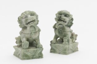 CHINE. Paire de lions assis en pierre dure verte p&#226;le sur des socles rectangulaires, 20e si...