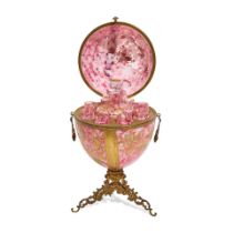 A MOSER BRASS MOUNTED GILT, SILVERED AND ENAMELLED PINK GLASS EGG-FORM TANTALUSEarly 20th century
