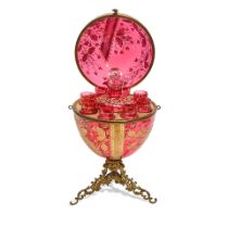 A MOSER BRASS MOUNTED GILT, SILVERED AND ENAMELLED RUBY GLASS EGG-FORM TANTALUSEarly 20th century