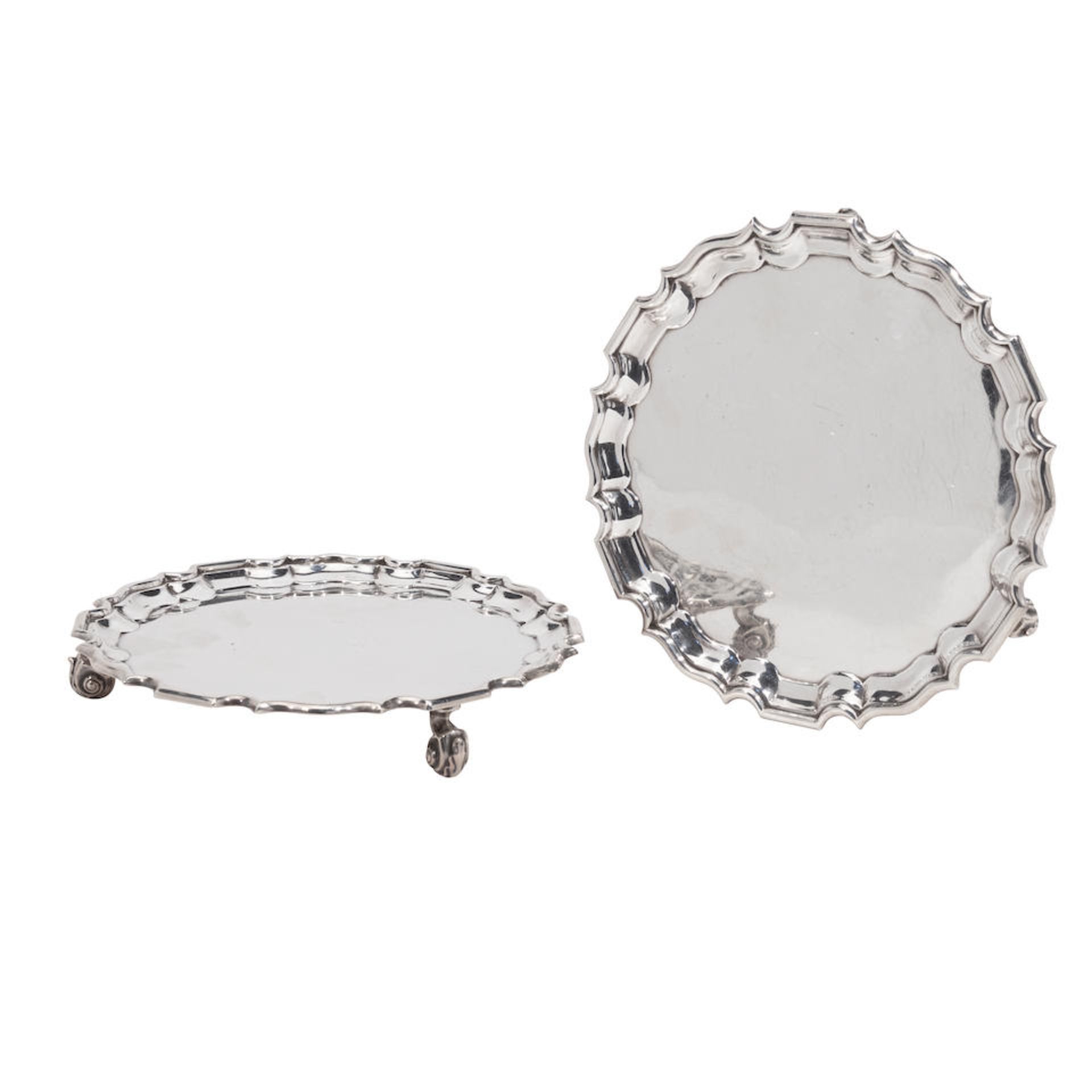 A MATCHED PAIR OF ENGLISH SILVER FOOTED SALVERS by various makers, 1930